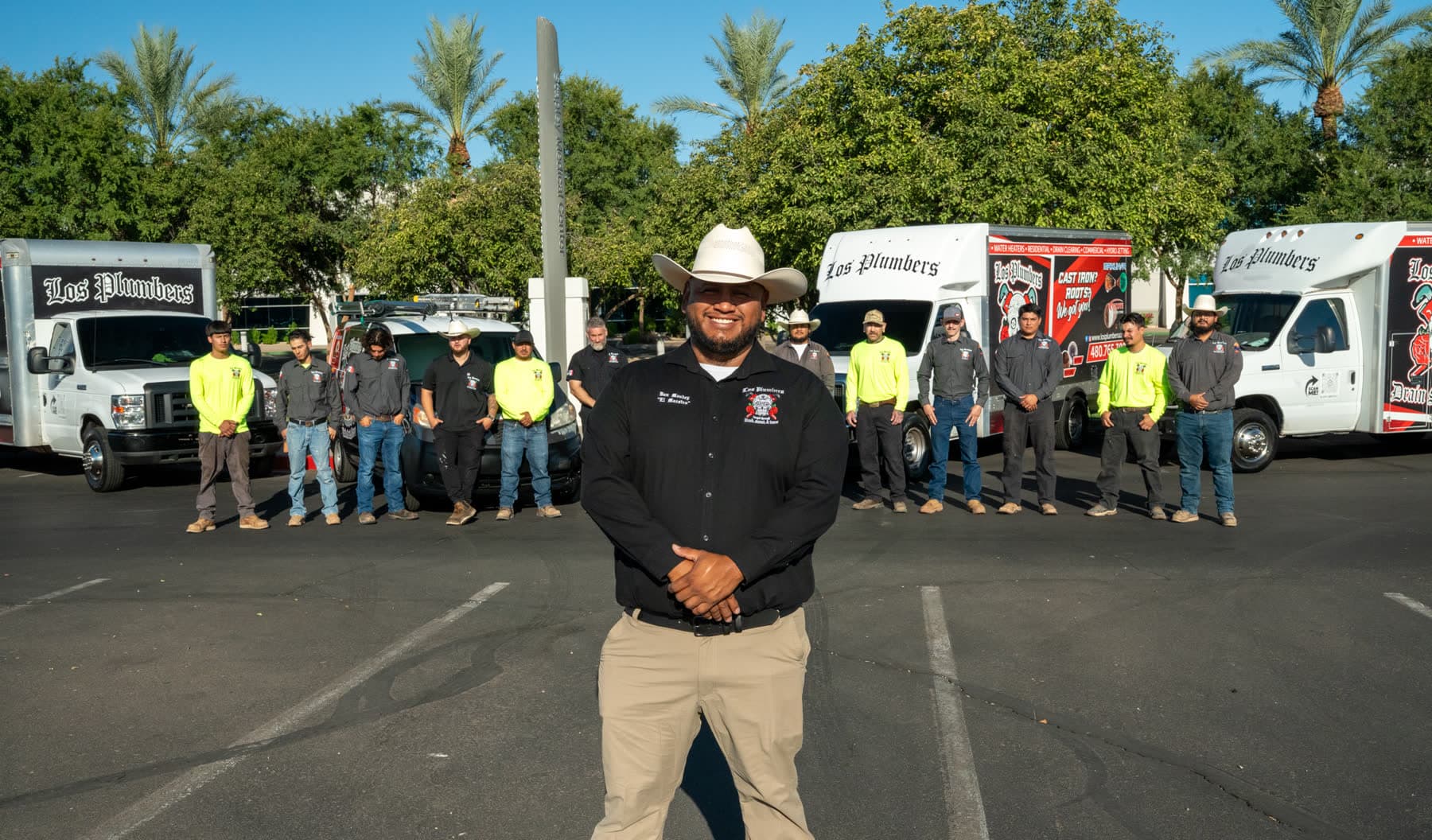 Dan Mendez and the full Los Plumbers crew in front of the fleet in Mesa