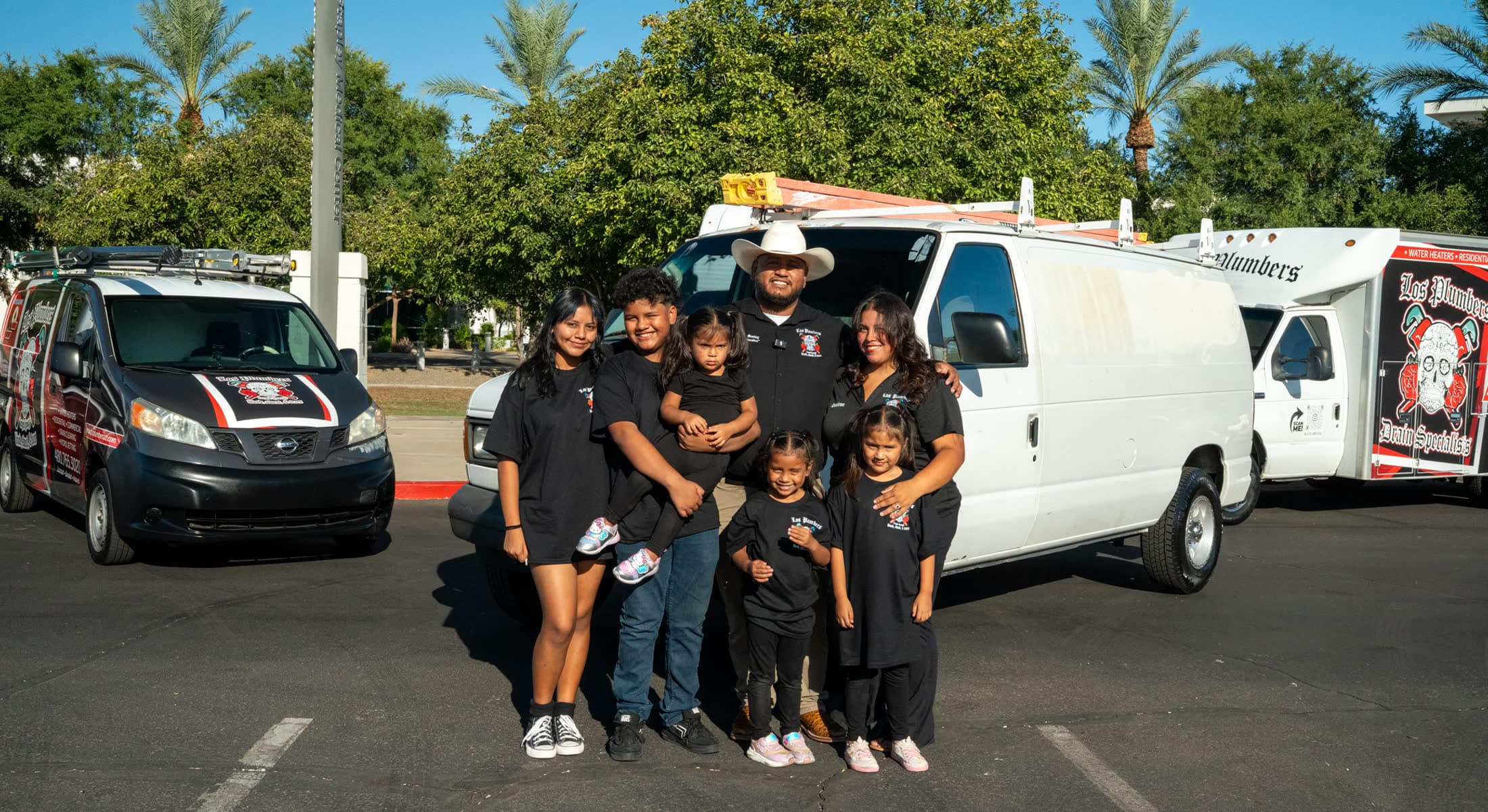 Dan and Desirae Mendez with their children in front of the Los Plumbers fleet